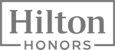 The image shows the logo of Hilton Honors, featuring bold text with "Hilton" on top and "HONORS" below in a rectangular frame.