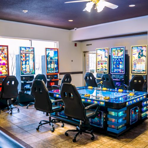 The image shows a casino-like room with multiple gaming machines, a central table setup, and swivel chairs arranged around it.