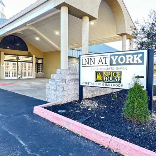 The image shows the entrance of "Inn at York," with a canopy, columns, and a sign mentioning conference facilities and a sports lounge.