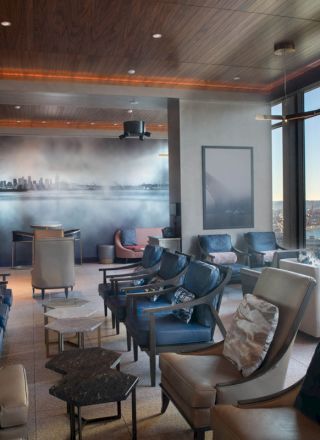 A modern lounge with comfortable seating, large windows offering a scenic view, and ambient lighting enhancing the stylish decor.
